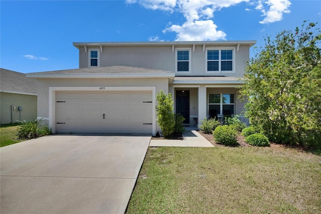 traditional-style house featuring an attached garage, concrete driveway, stucco siding, and a front yard