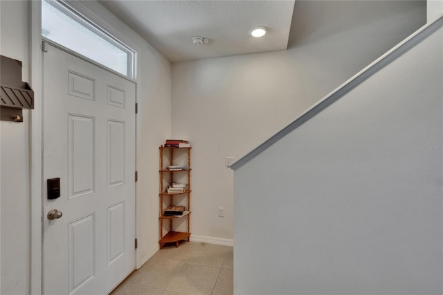 foyer entrance featuring light tile patterned floors and baseboards