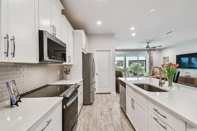 19398 Great Intention Way, Lutz, FL 33558 - kitchen with a sink, tasteful backsplash, white cabinetry, light countertops, and appliances with stainless steel finishes