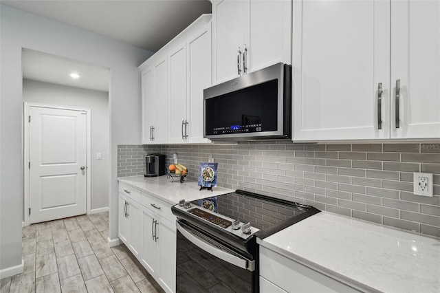 19398 Great Intention Way, Lutz, FL 33558 - kitchen featuring decorative backsplash, white cabinetry, and stainless steel appliances