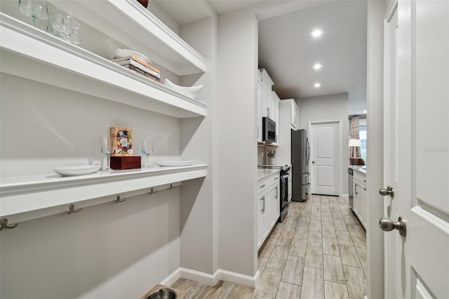19398 Great Intention Way, Lutz, FL 33558 - kitchen with white cabinets, light wood-style flooring, stainless steel appliances, and light countertops