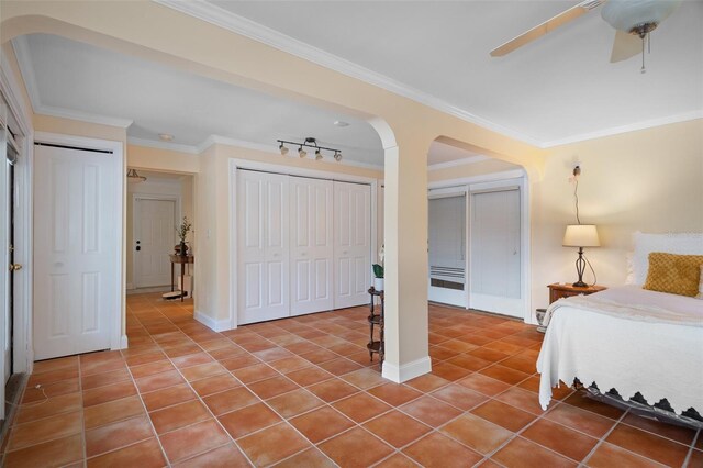 378 Tennessee Ave, Crystal Beach, FL 34681 - tiled bedroom with arched walkways, two closets, ceiling fan, and crown molding