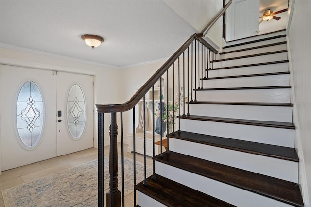 378 Tennessee Ave, Crystal Beach, FL 34681 - entrance foyer featuring light tile patterned floors, a textured ceiling, stairway, and crown molding