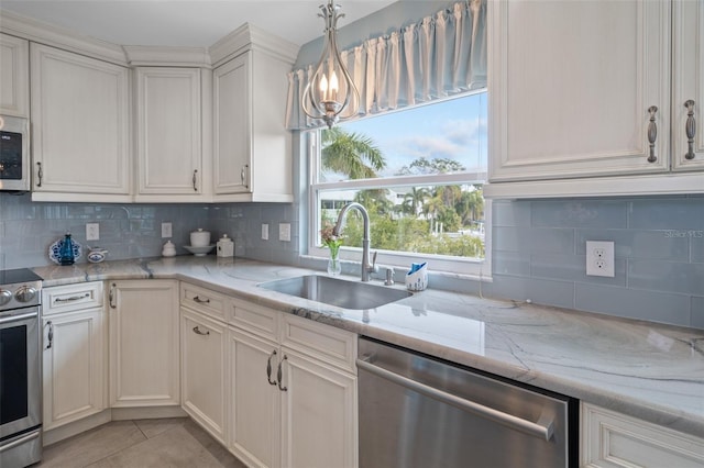 378 Tennessee Ave, Crystal Beach, FL 34681 - kitchen featuring tasteful backsplash, an inviting chandelier, stainless steel appliances, a sink, and light tile patterned flooring