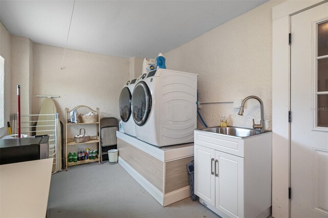 378 Tennessee Ave, Crystal Beach, FL 34681 - laundry area featuring cabinet space, a sink, a textured wall, and washing machine and dryer