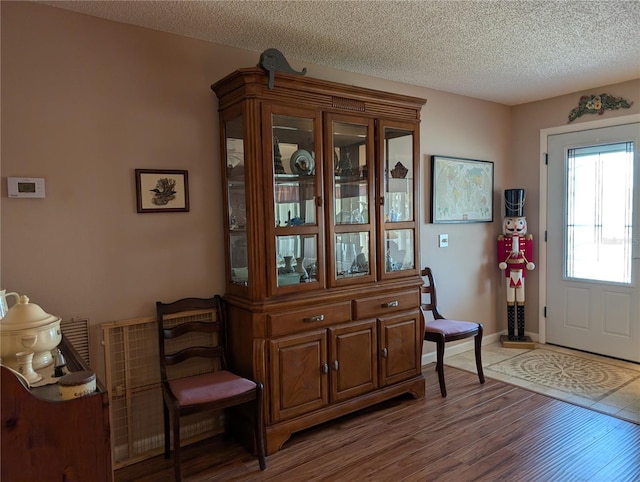 entryway featuring baseboards, wood finished floors, and a textured ceiling