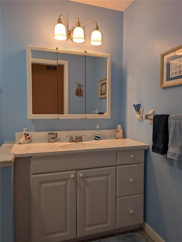 bathroom with baseboards, visible vents, and vanity