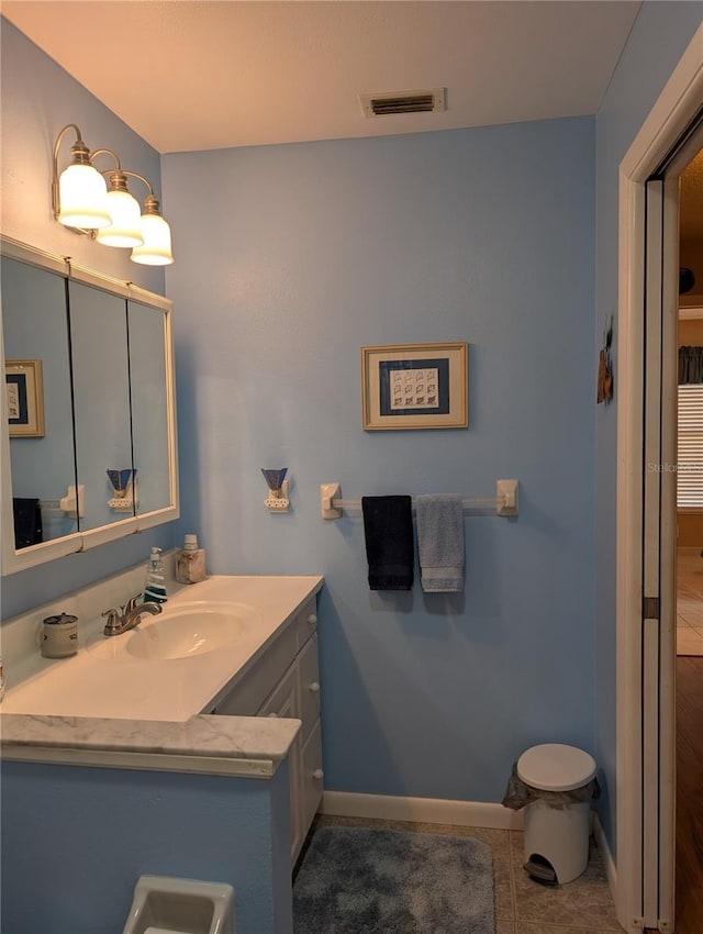 bathroom featuring baseboards, visible vents, tile patterned flooring, and vanity