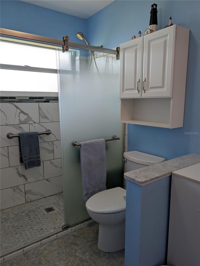 bathroom featuring a stall shower and toilet