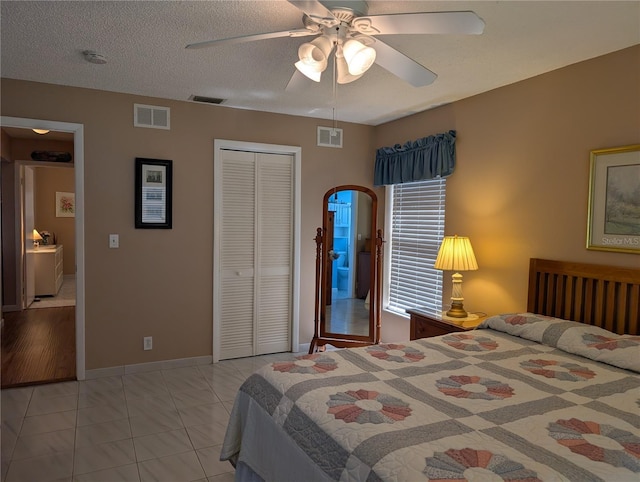 bedroom featuring light tile patterned flooring, visible vents, and a closet