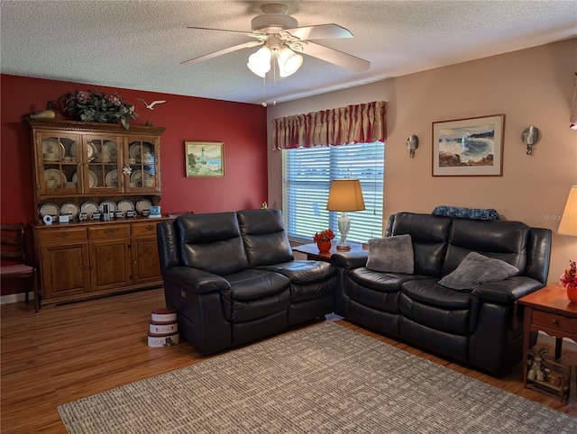 living area featuring a ceiling fan, a textured ceiling, and wood finished floors