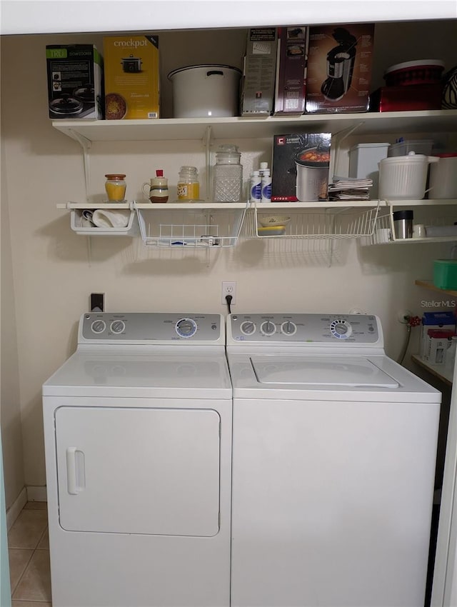washroom featuring washing machine and dryer, laundry area, and tile patterned flooring