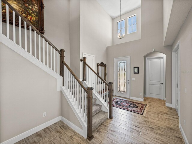 12808 Boggy Creek Dr, Riverview, FL 33579 - entryway with a notable chandelier, stairway, baseboards, wood tiled floor, and a towering ceiling