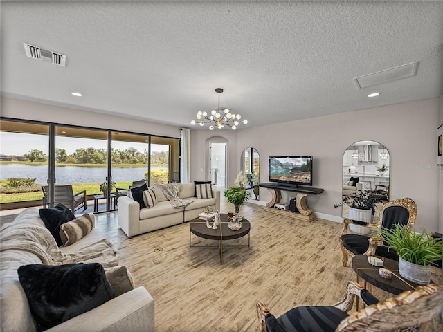 12808 Boggy Creek Dr, Riverview, FL 33579 - living area with baseboards, a textured ceiling, visible vents, a notable chandelier, and wood finished floors