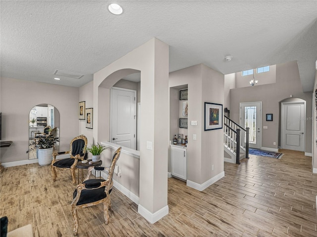 12808 Boggy Creek Dr, Riverview, FL 33579 - entrance foyer featuring baseboards, light wood-type flooring, arched walkways, and a textured ceiling