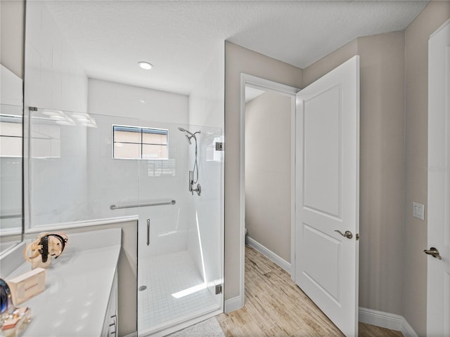 12808 Boggy Creek Dr, Riverview, FL 33579 - full bath featuring a shower stall, baseboards, wood finished floors, and a textured ceiling