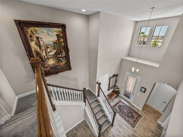 12808 Boggy Creek Dr, Riverview, FL 33579 - staircase with baseboards, wood finished floors, a textured ceiling, and an inviting chandelier