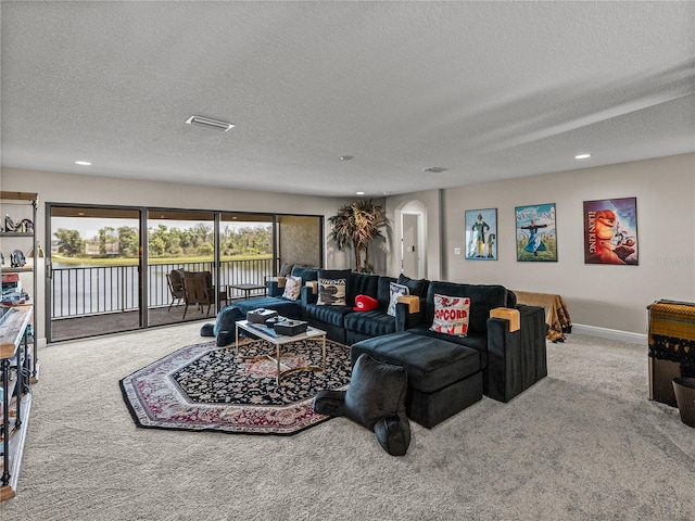 12808 Boggy Creek Dr, Riverview, FL 33579 - carpeted living area with a textured ceiling, visible vents, baseboards, recessed lighting, and arched walkways