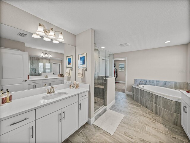12808 Boggy Creek Dr, Riverview, FL 33579 - bathroom featuring vanity, a shower stall, a garden tub, visible vents, and a notable chandelier