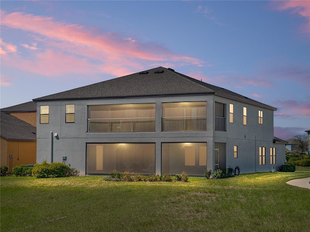 12808 Boggy Creek Dr, Riverview, FL 33579 - back of property at dusk featuring a lawn and stucco siding