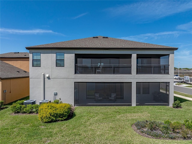 12808 Boggy Creek Dr, Riverview, FL 33579 - rear view of house with roof with shingles, a balcony, stucco siding, and a yard