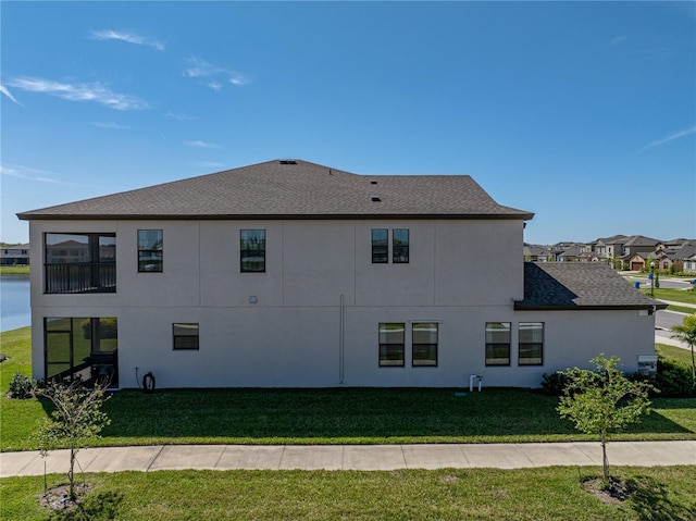 12808 Boggy Creek Dr, Riverview, FL 33579 - view of side of home with stucco siding, a shingled roof, a water view, and a yard