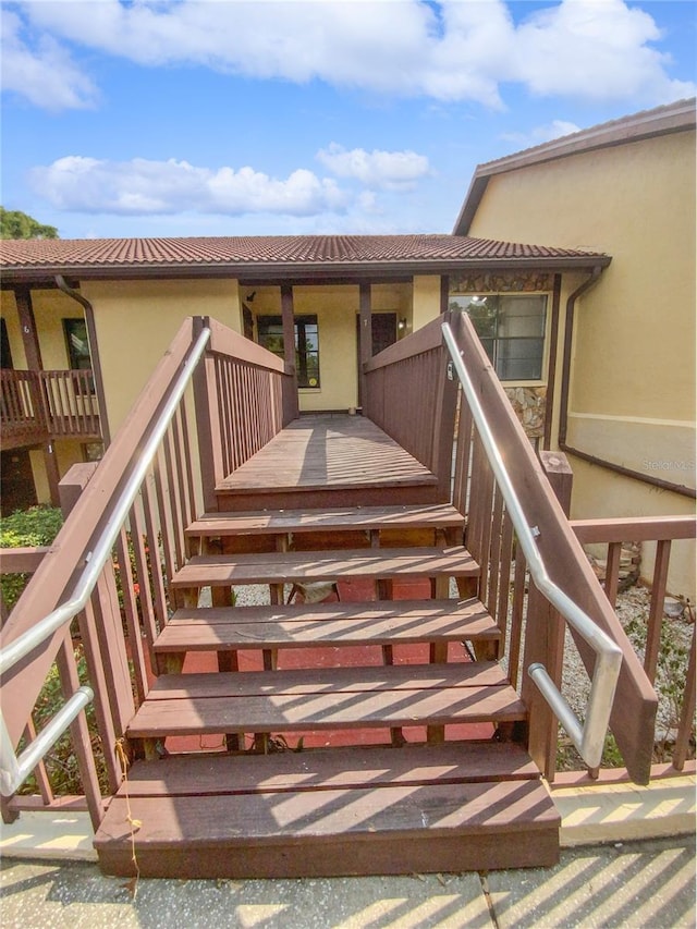 view of exterior entry with a tiled roof and stucco siding