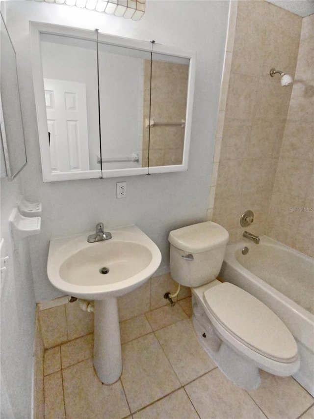 bathroom featuring a sink, toilet, washtub / shower combination, and tile patterned flooring