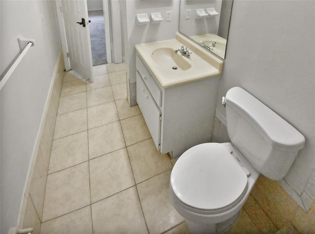 half bathroom with vanity, tile patterned floors, toilet, and baseboards