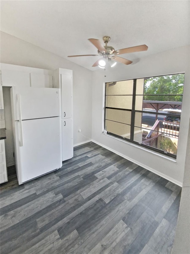 spare room featuring dark wood-type flooring, baseboards, and ceiling fan