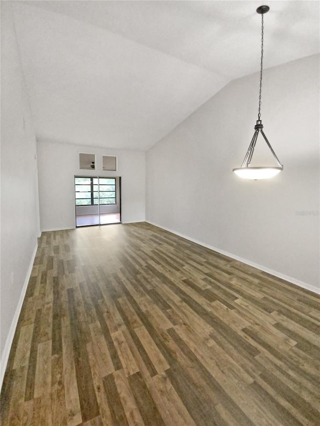 spare room featuring lofted ceiling, wood finished floors, and baseboards