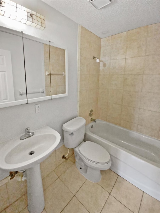 bathroom featuring tile patterned flooring, toilet, tub / shower combination, and a textured ceiling