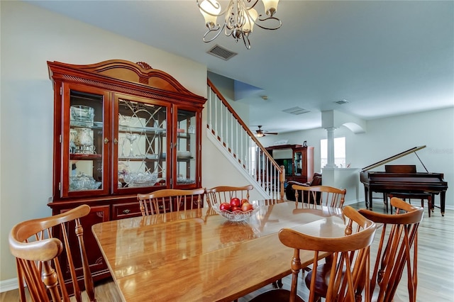 4250 Warwick Hills Dr, Wesley Chapel, FL 33543 - dining area with ornate columns, stairs, wood finished floors, a chandelier, and baseboards