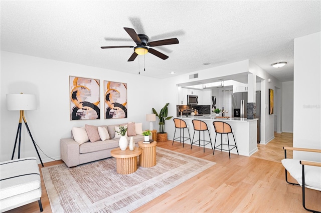 408 S Arrawana Ave Unit B4, Tampa, FL 33609 - living area featuring ceiling fan, light wood-type flooring, a textured ceiling, visible vents, and baseboards