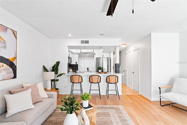 408 S Arrawana Ave Unit B4, Tampa, FL 33609 - living room with ceiling fan, light wood-type flooring, a textured ceiling, visible vents, and baseboards