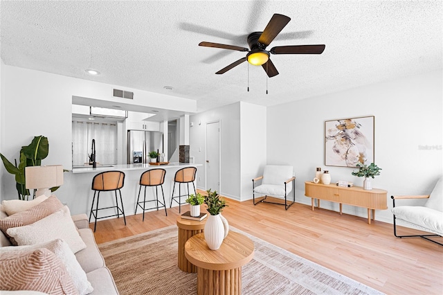 408 S Arrawana Ave Unit B4, Tampa, FL 33609 - living room featuring baseboards, a textured ceiling, a ceiling fan, visible vents, and light wood finished floors