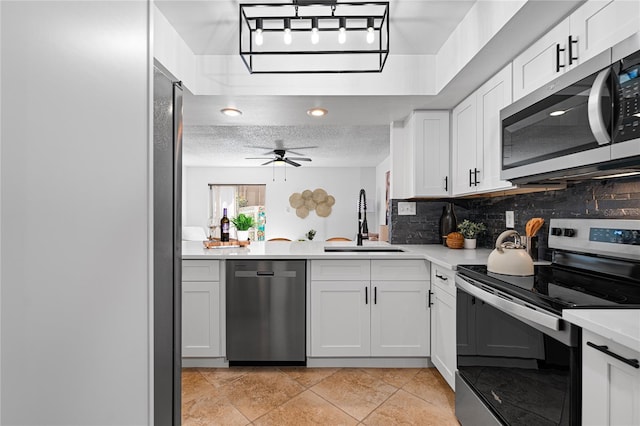 408 S Arrawana Ave Unit B4, Tampa, FL 33609 - kitchen featuring tasteful backsplash, a sink, light countertops, appliances with stainless steel finishes, and white cabinetry