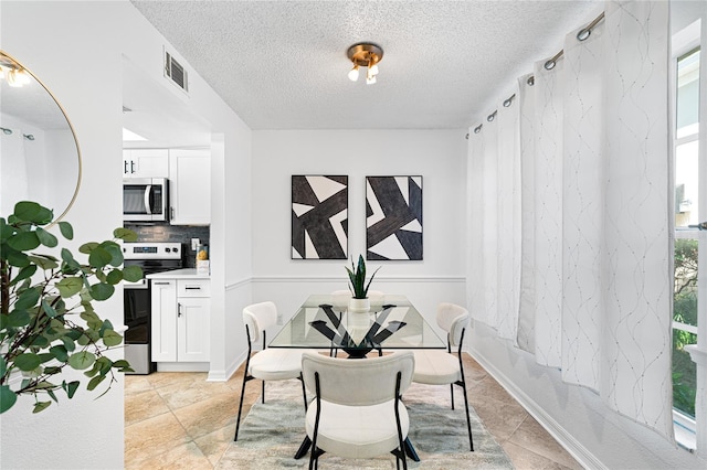 408 S Arrawana Ave Unit B4, Tampa, FL 33609 - dining room featuring visible vents and a textured ceiling