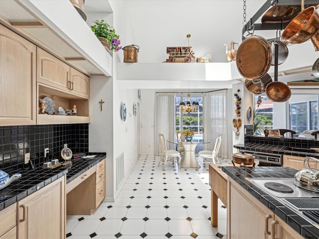 kitchen with tile counters, light brown cabinets, a wealth of natural light, and light floors