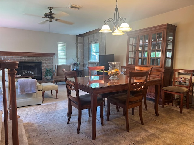 3316 S Shamrock Rd, Tampa, FL 33629 - dining area with light tile patterned floors, ceiling fan, a brick fireplace, and a chandelier