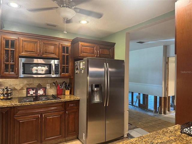 3316 S Shamrock Rd, Tampa, FL 33629 - kitchen featuring stainless steel appliances, decorative backsplash, a ceiling fan, glass insert cabinets, and stone countertops