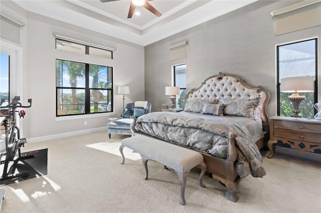 carpeted bedroom with crown molding, a tray ceiling, baseboards, a towering ceiling, and ceiling fan