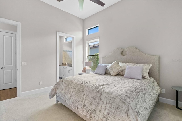 carpeted bedroom featuring baseboards, ensuite bathroom, and a ceiling fan