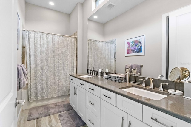 bathroom with double vanity, a sink, shower / tub combo with curtain, and visible vents