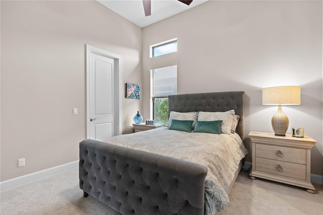 bedroom with baseboards, multiple windows, a ceiling fan, and light carpet