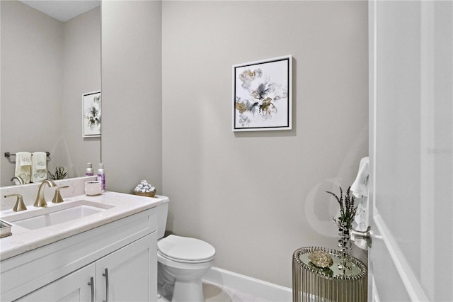 bathroom featuring baseboards, toilet, and vanity