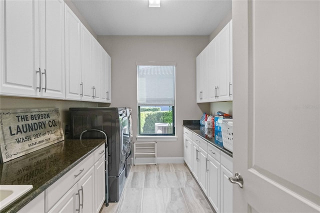 laundry area with separate washer and dryer and cabinet space