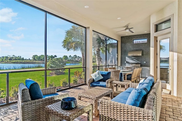 sunroom / solarium featuring outdoor lounge area, a water view, and a ceiling fan