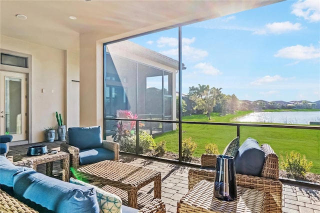 sunroom / solarium featuring an outdoor living space and a water view