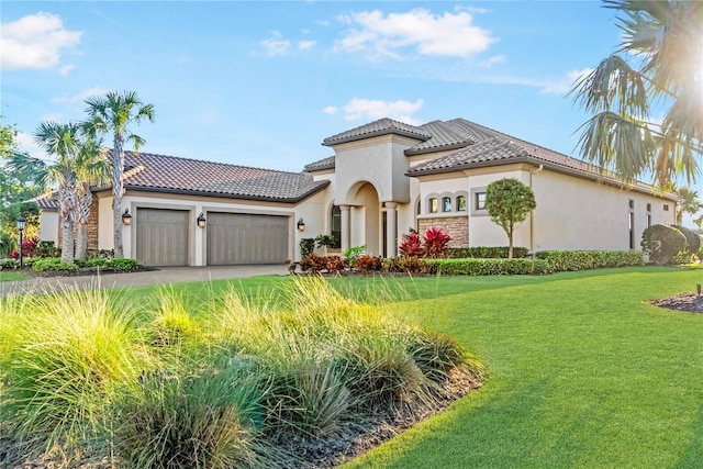 mediterranean / spanish-style house with a front yard, stucco siding, an attached garage, and a tiled roof